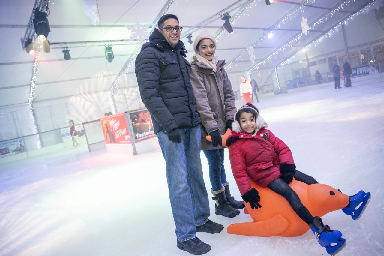 Ice Rink Leicester man and woman with child on a seal skate aid