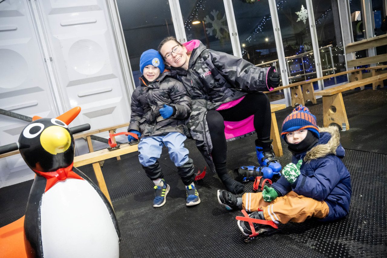 Family at ice rink with penguin skate aid